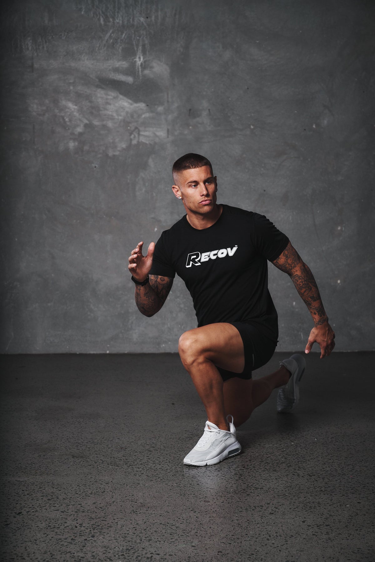 An athlete in a Recov training shirt holding a lunge
