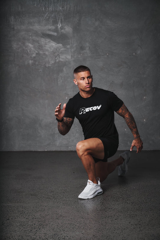 An athlete in a Recov shirt lunging during training