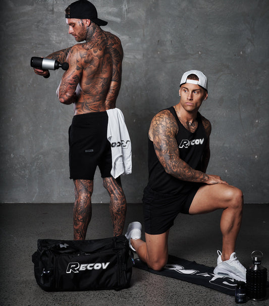 Two athletes training beside a Recov kit bag