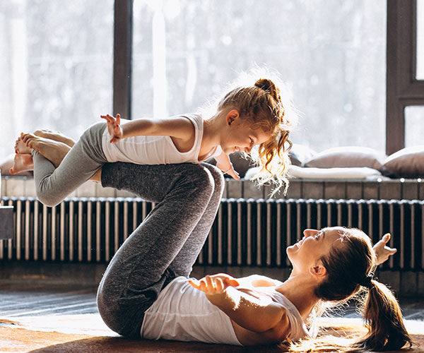 Mum and daughter doing yoga at home
